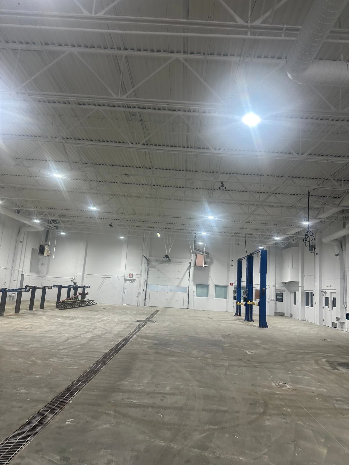 The same shop floor after painting: walls and ceiling in clean white, the whole space visibly brighter