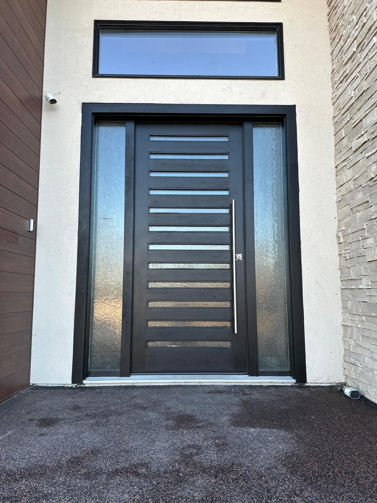 Finished modern front entrance with the satin black door and clean stucco surround