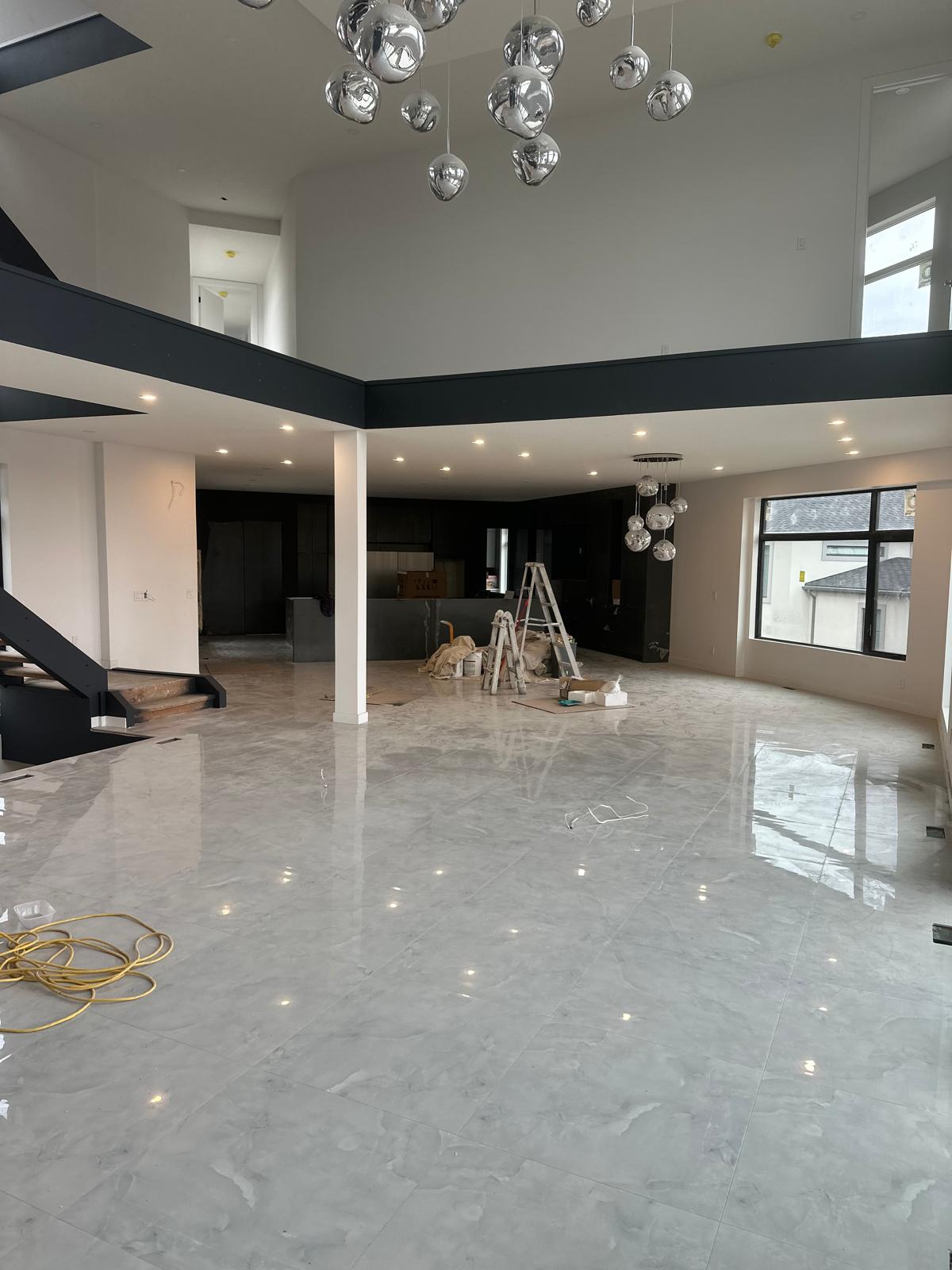 Finished open-concept main floor with polished marble floors, white walls, and dark cabinetry